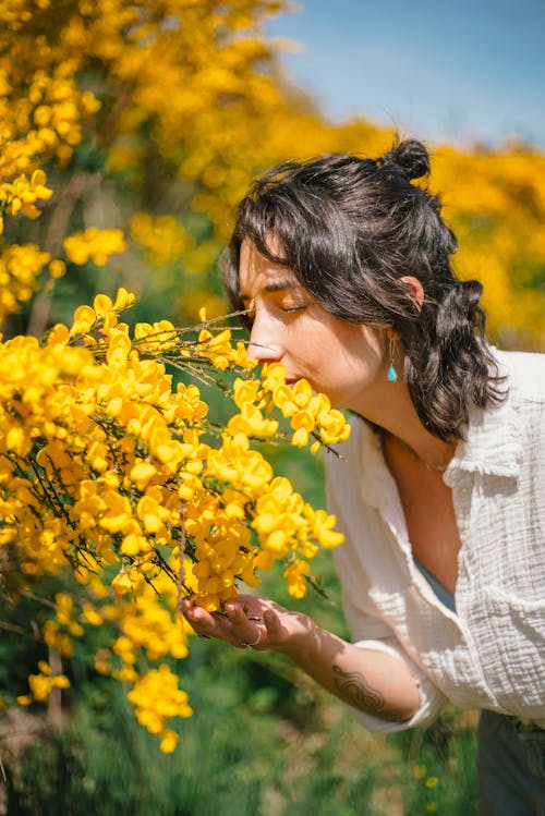 A woman smelling flowers in a field