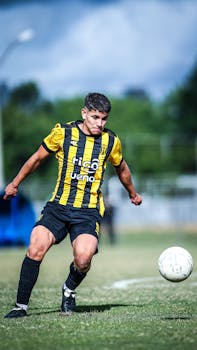 Soccer player in motion on the field in a competitive match.