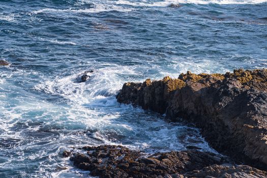 Crashing waves against rocky cliffs on the scenic Big Sur coastline in California.