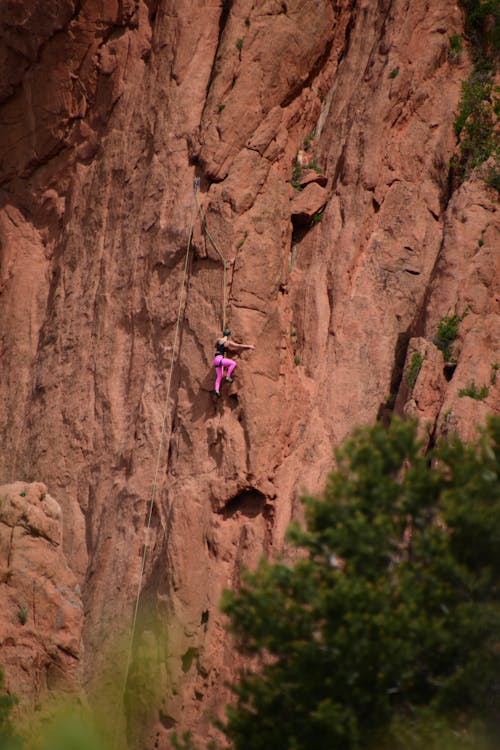 A person climbing up a rock face in the mountains