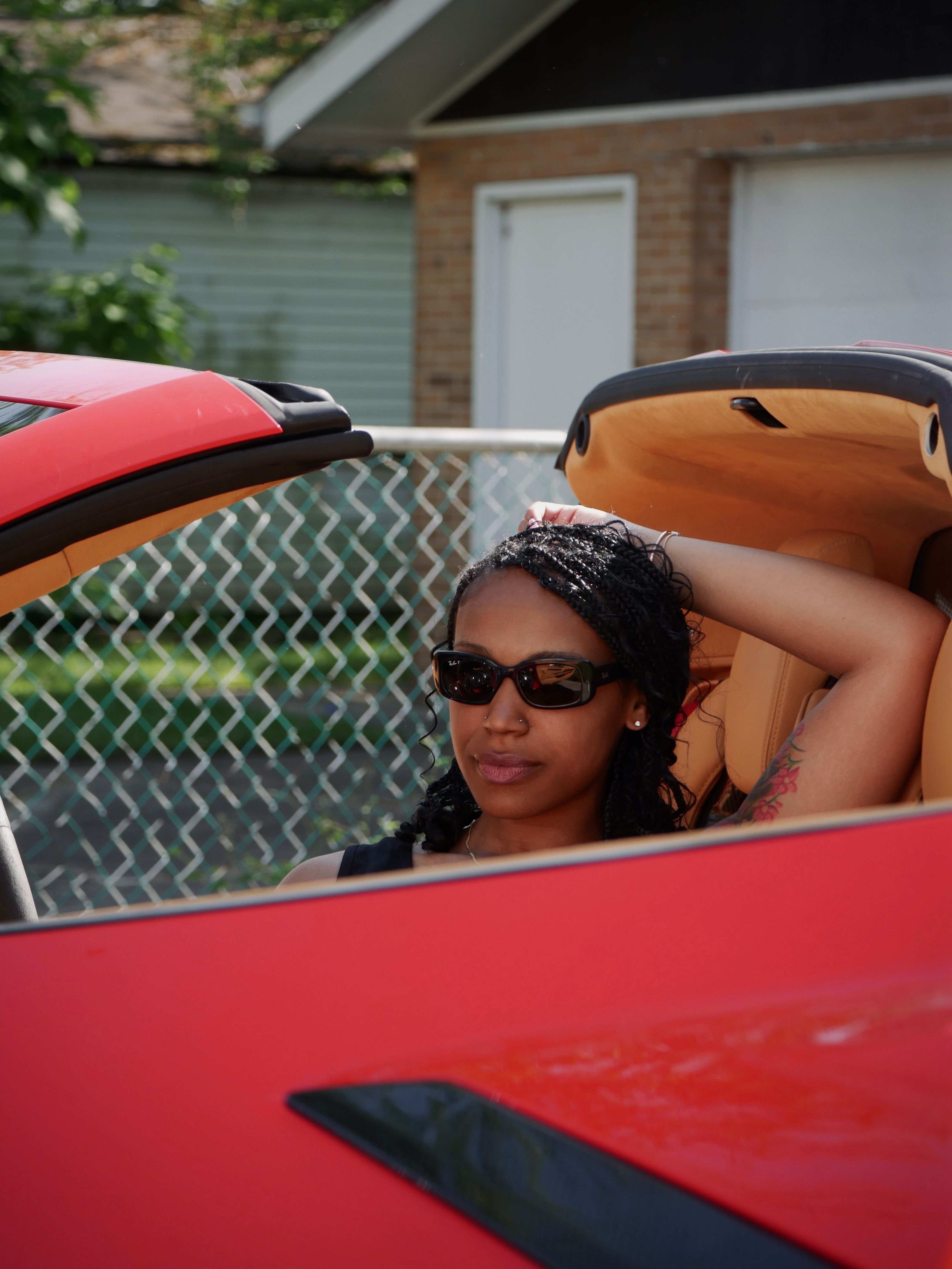 A woman with sunglasses sitting in a red sports car · Free Stock Photo