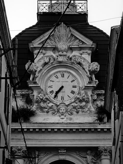 A black and white photo of a clock on a building