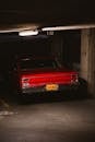 一辆充满活力的红色经典肌肉车停在芝加哥光线昏暗的地下车库里