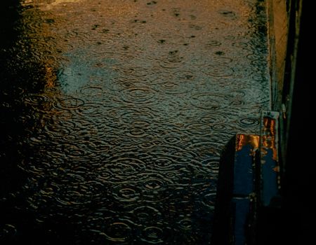 Moody night scene of rain ripples on a street in Chicago, USA.
