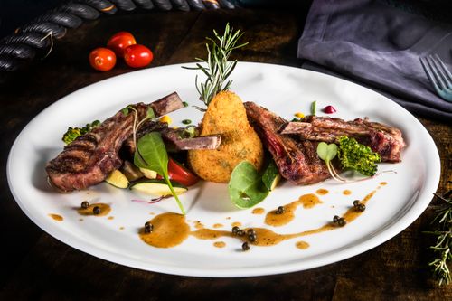 Free Delight in a gourmet lamb chop meal with vibrant vegetables and herbs on a elegant plate. Stock Photo