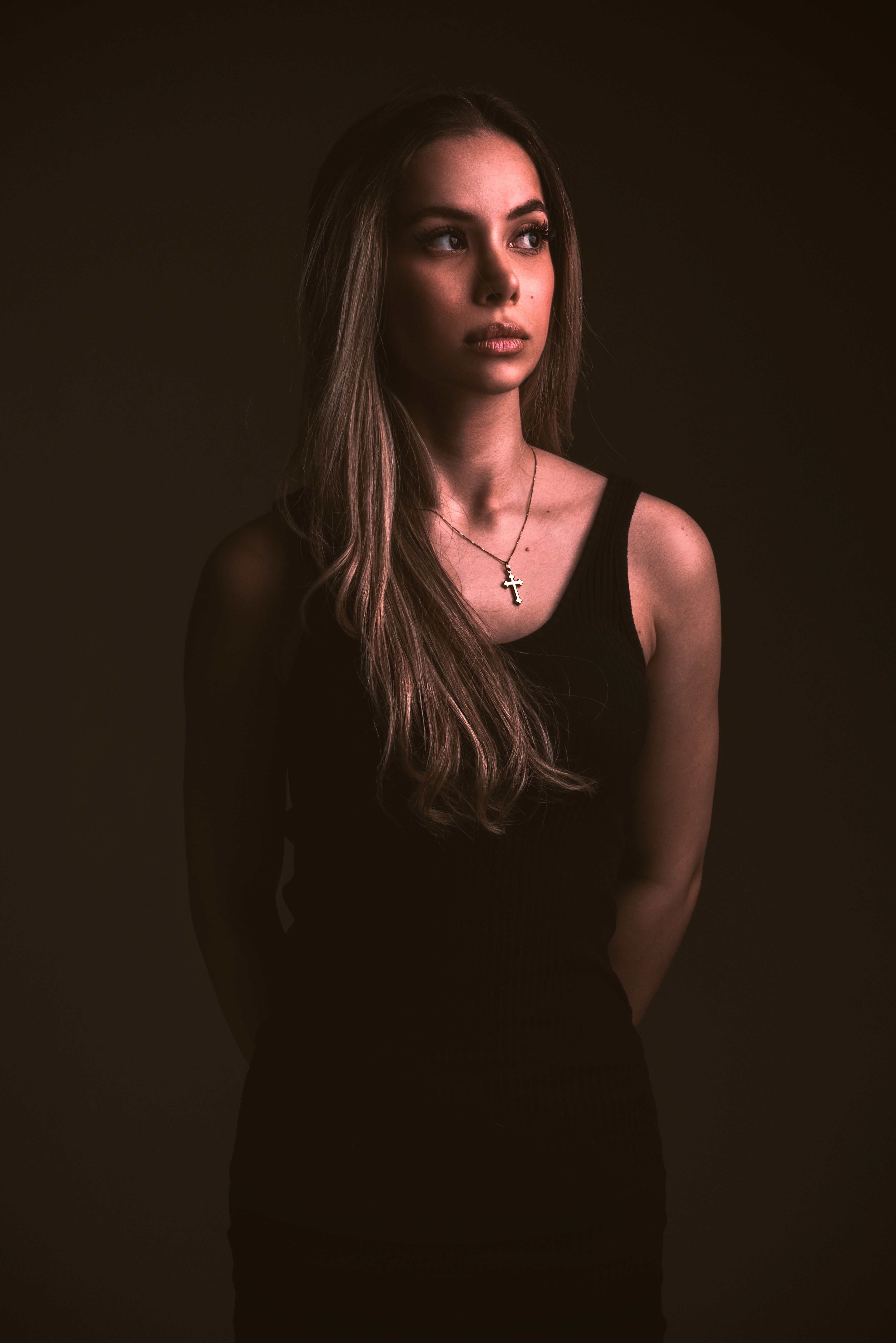 A sophisticated studio portrait of a woman in a black dress, showcasing a fashion-forward look with dramatic lighting.. pexel