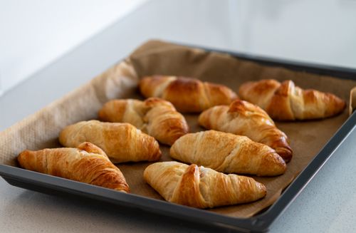 Free Freshly baked croissants cooling on a tray, ideal for cozy breakfast settings. Stock Photo