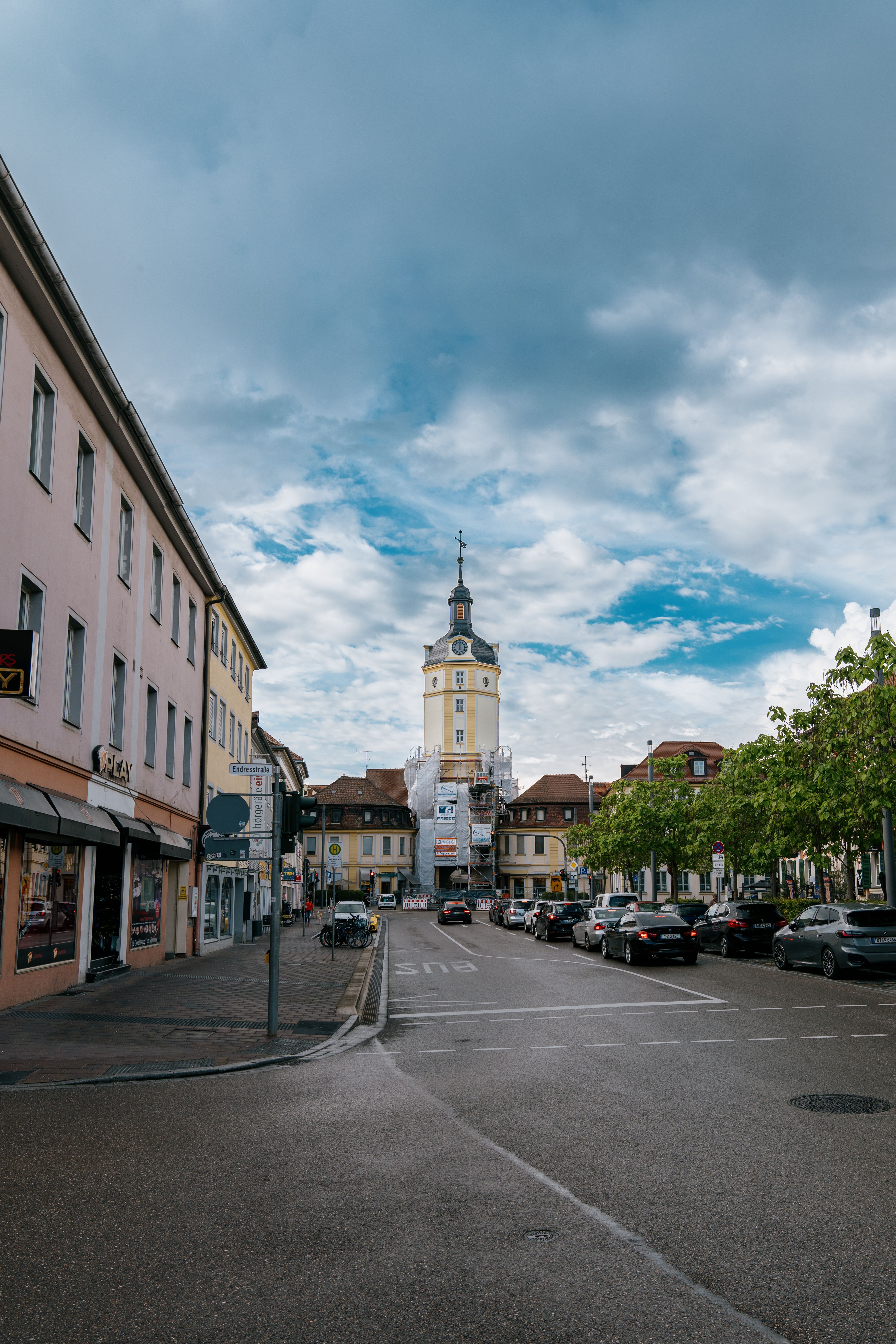 A vibrant city street scene featuring the historic Herrieder Tor in Ansbach, Germany.