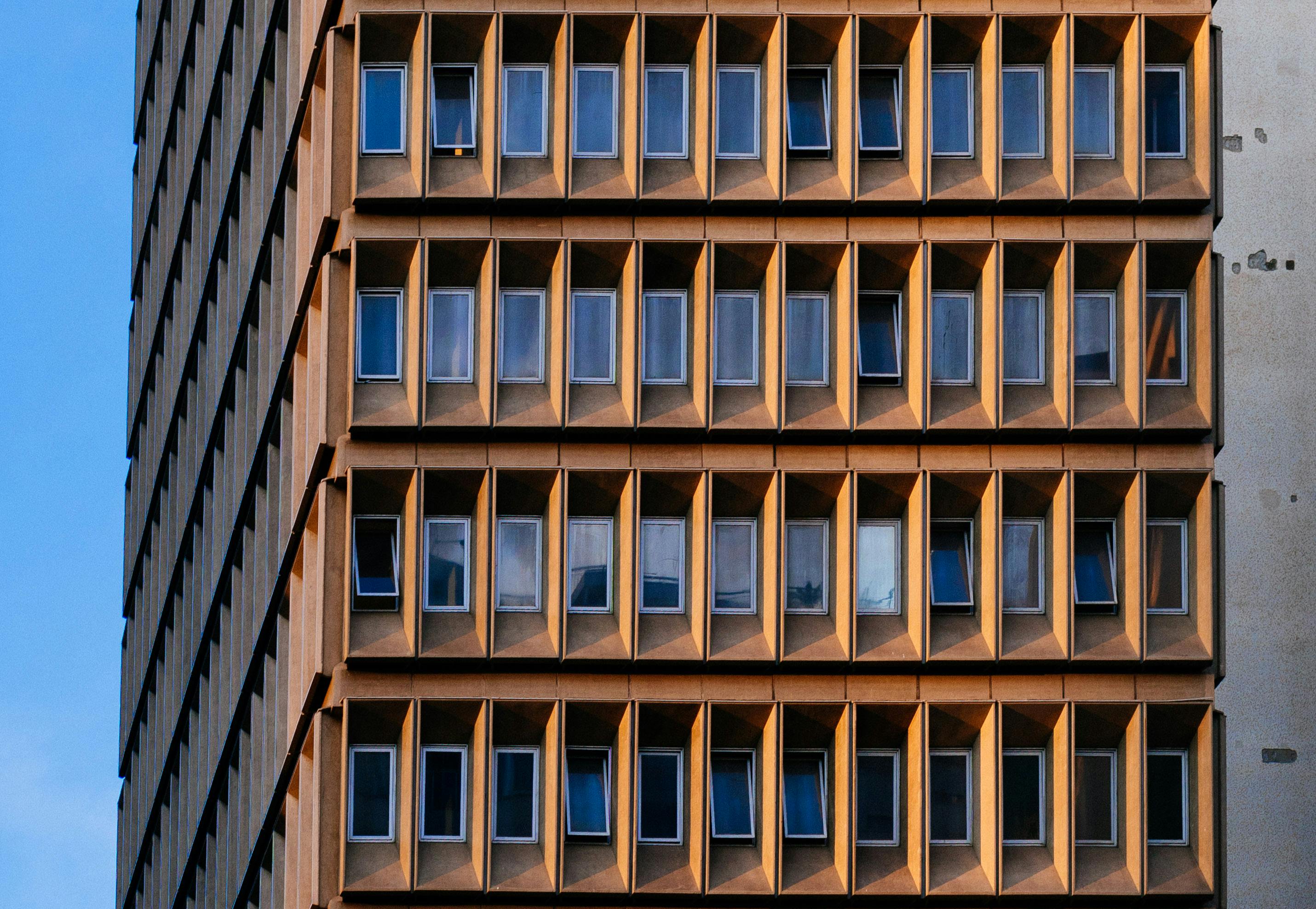 现代高层建筑立面的特写视图，展现了具有现代设计感的几何窗户图案