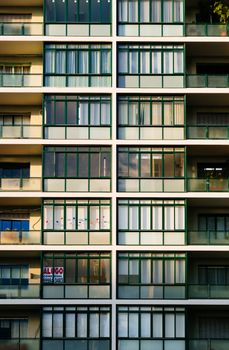 Close-up of modern apartment building facade with balconies and glass windows.