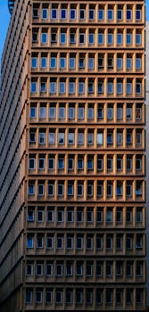 在温暖的阳光下，高层建筑立面的几何形特写视图显得格外均匀