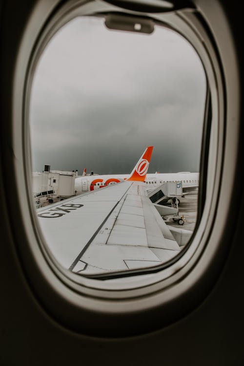 Free View of airplane wing through plane window Stock Photo
