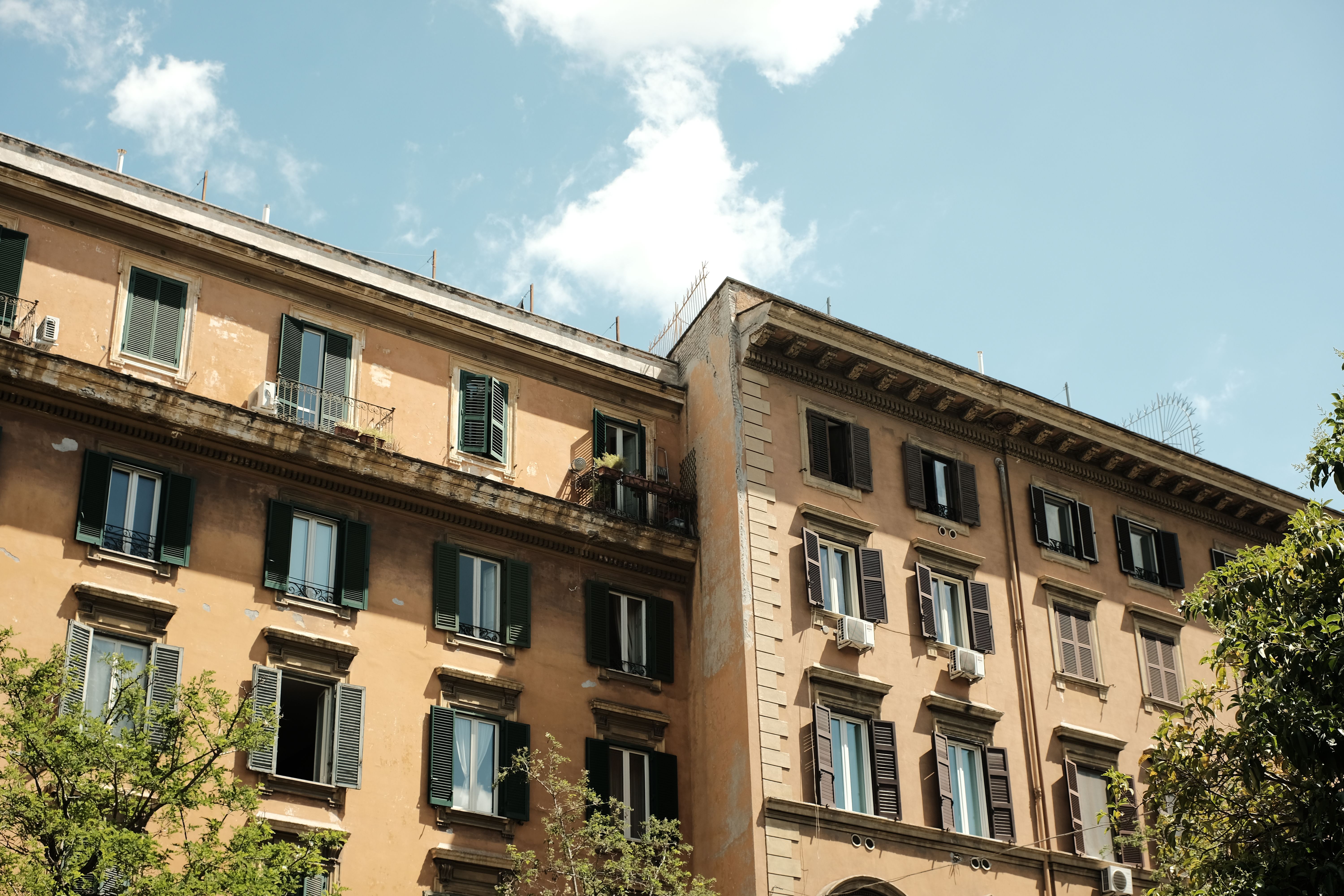 Charming view of historic apartment buildings under clear skies in Rome, Italy.