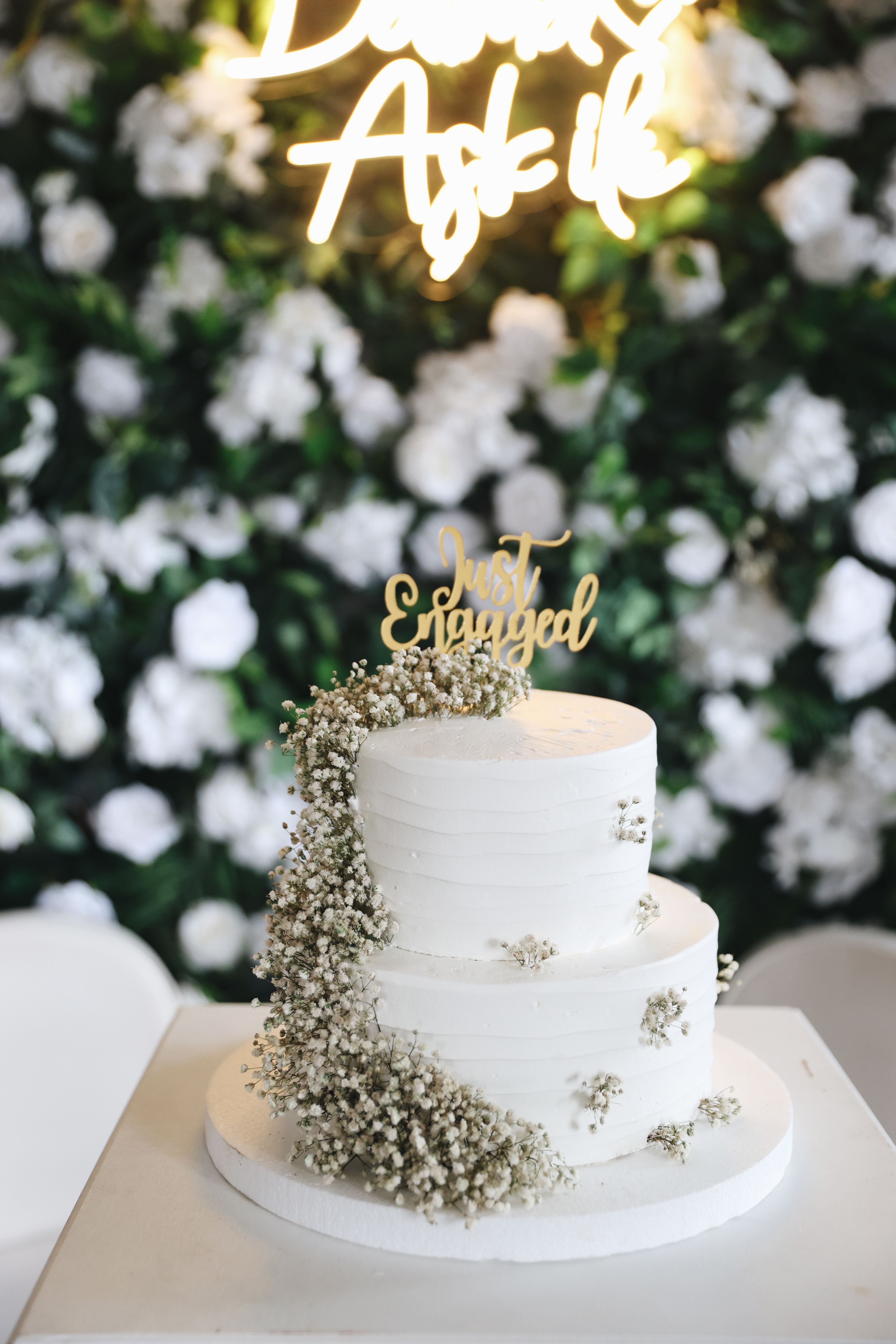 Three-tier engagement cake with baby's breath flowers