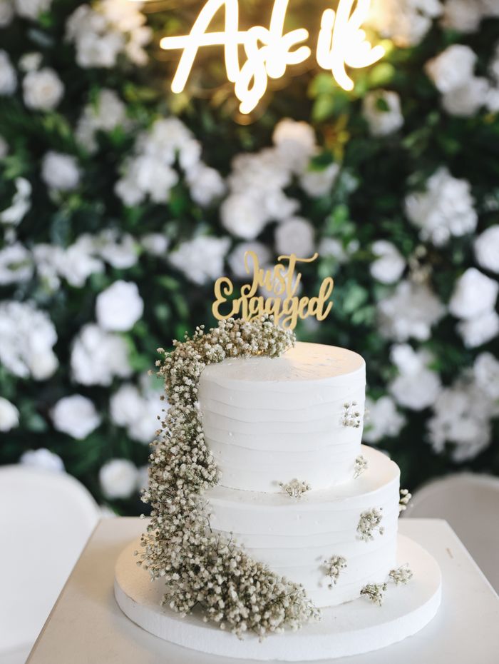 Three-tier engagement cake with baby's breath flowers