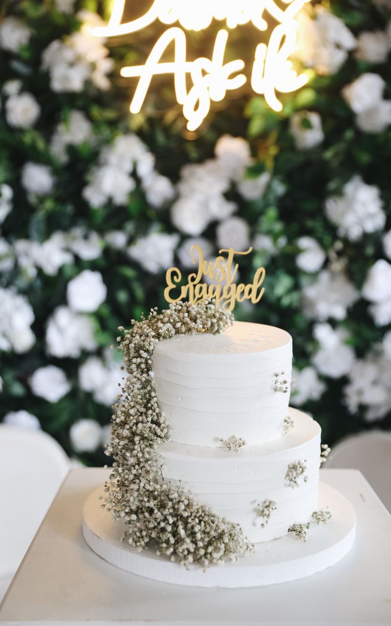 Three-tier engagement cake with baby's breath flowers