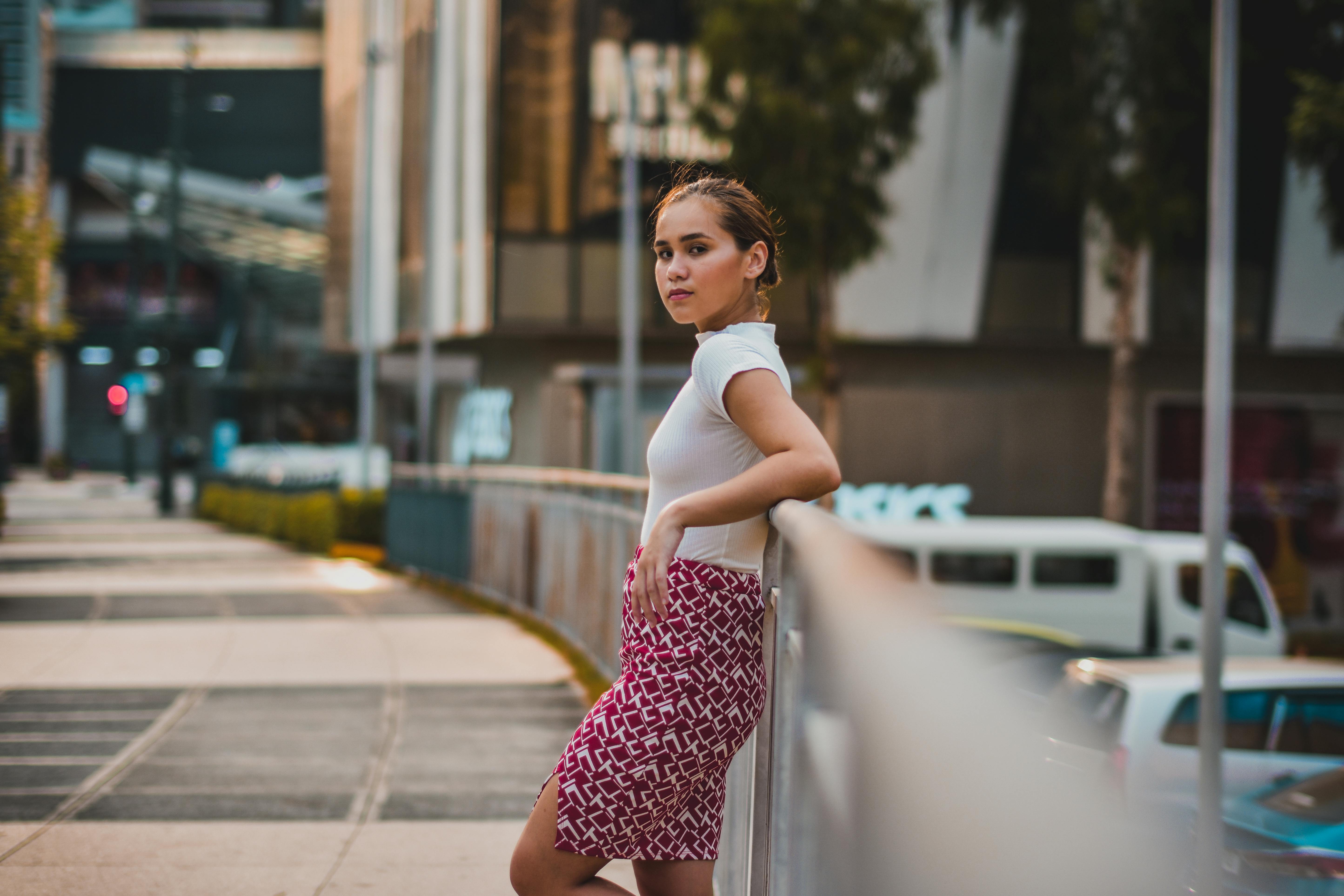 一位年轻时尚的女子在现代都市的街道上摆出户外姿势