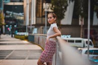 一位年轻时尚的女子在现代都市的街道上摆出户外姿势