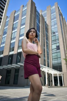 一个时髦的女人在一座现代化城市的摩天大楼前摆姿势