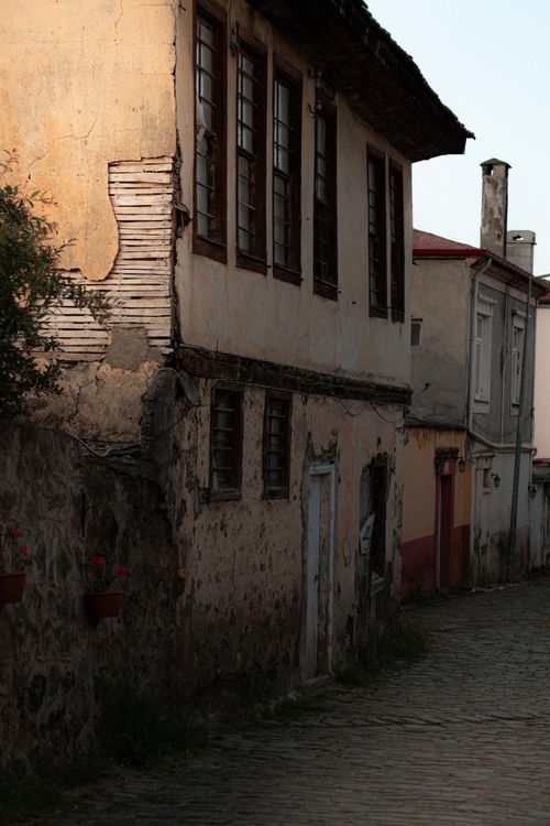 Free A rustic, abandoned townhouse under soft light on a cobblestone street, evoking historic urban charm. Stock Photo
