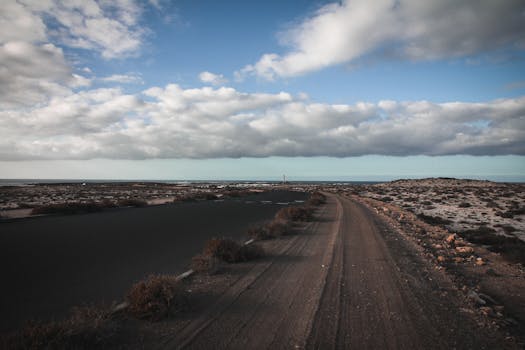 土路在多云的天空下向地平线延伸，非常适合旅行和冒险主题