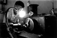 Black and White Shot of a Man Working in a Workshop
