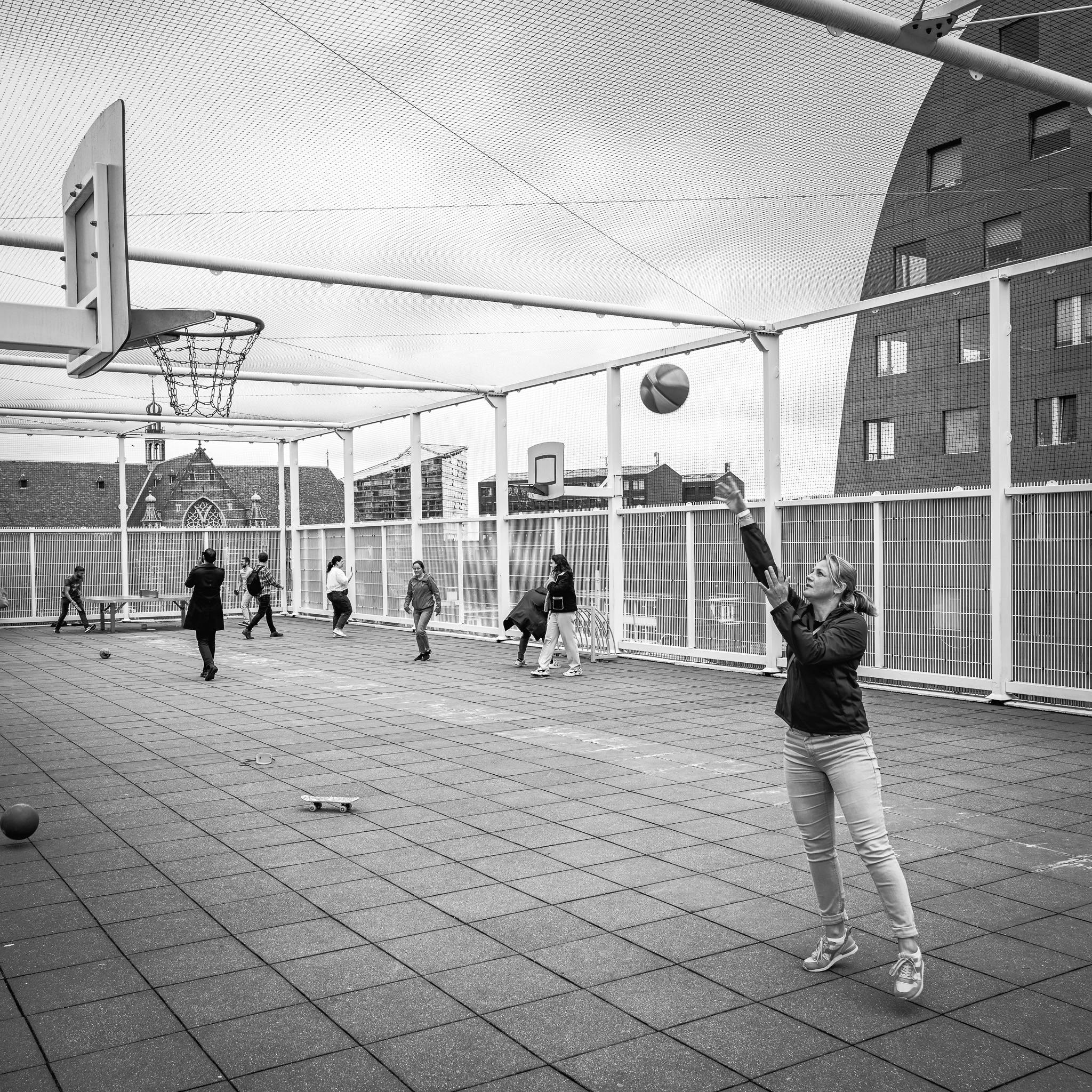 Black and White Shot of a Young Woman Playing Basketball 