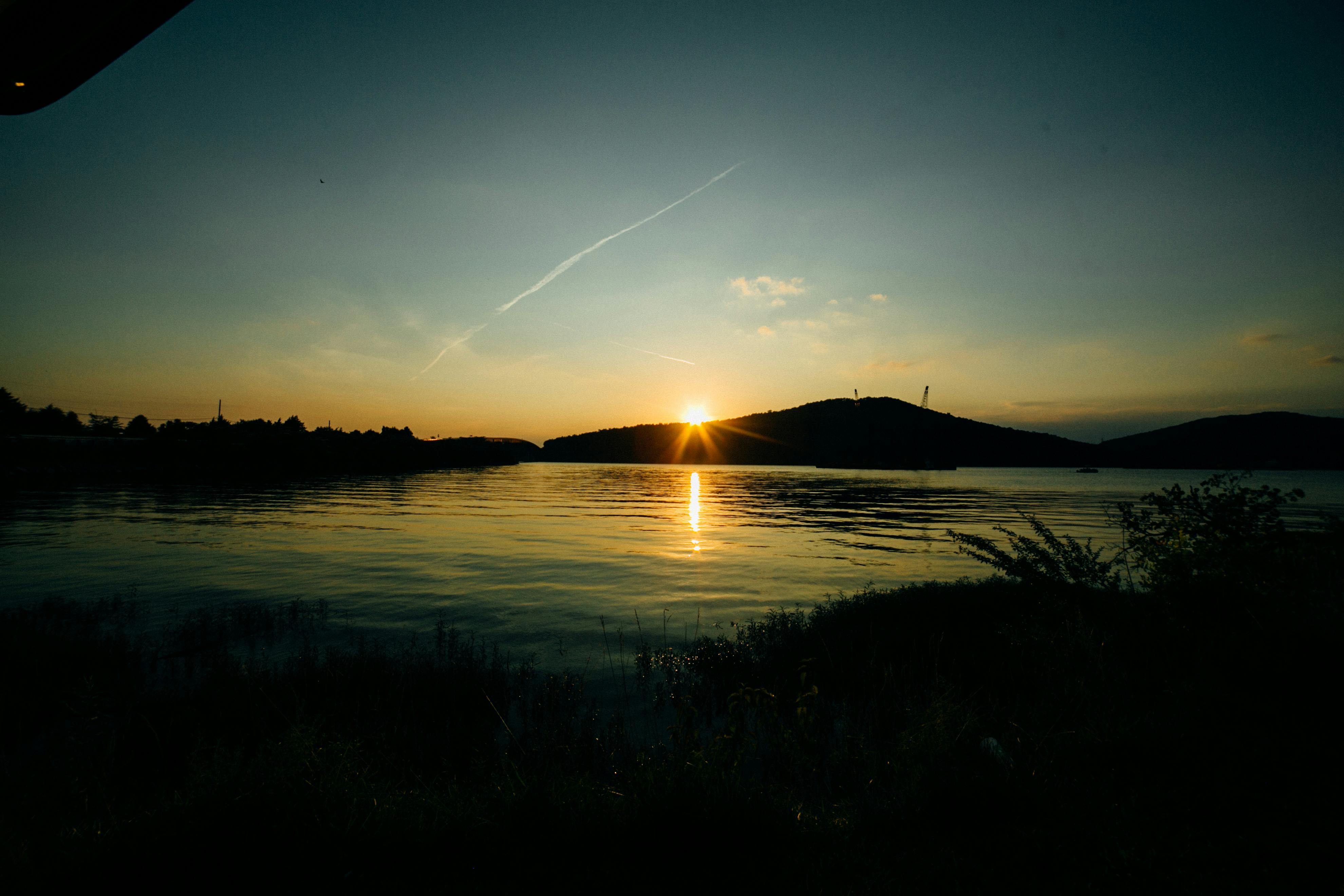 田纳西州湖泊上，日落景色宁静，色彩鲜艳，水面平静