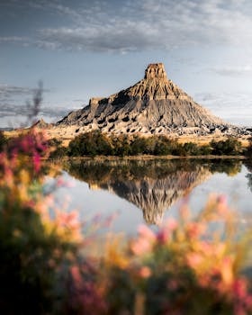平静的湖面倒映着雄伟的山峰，四周环绕着色彩缤纷的植物