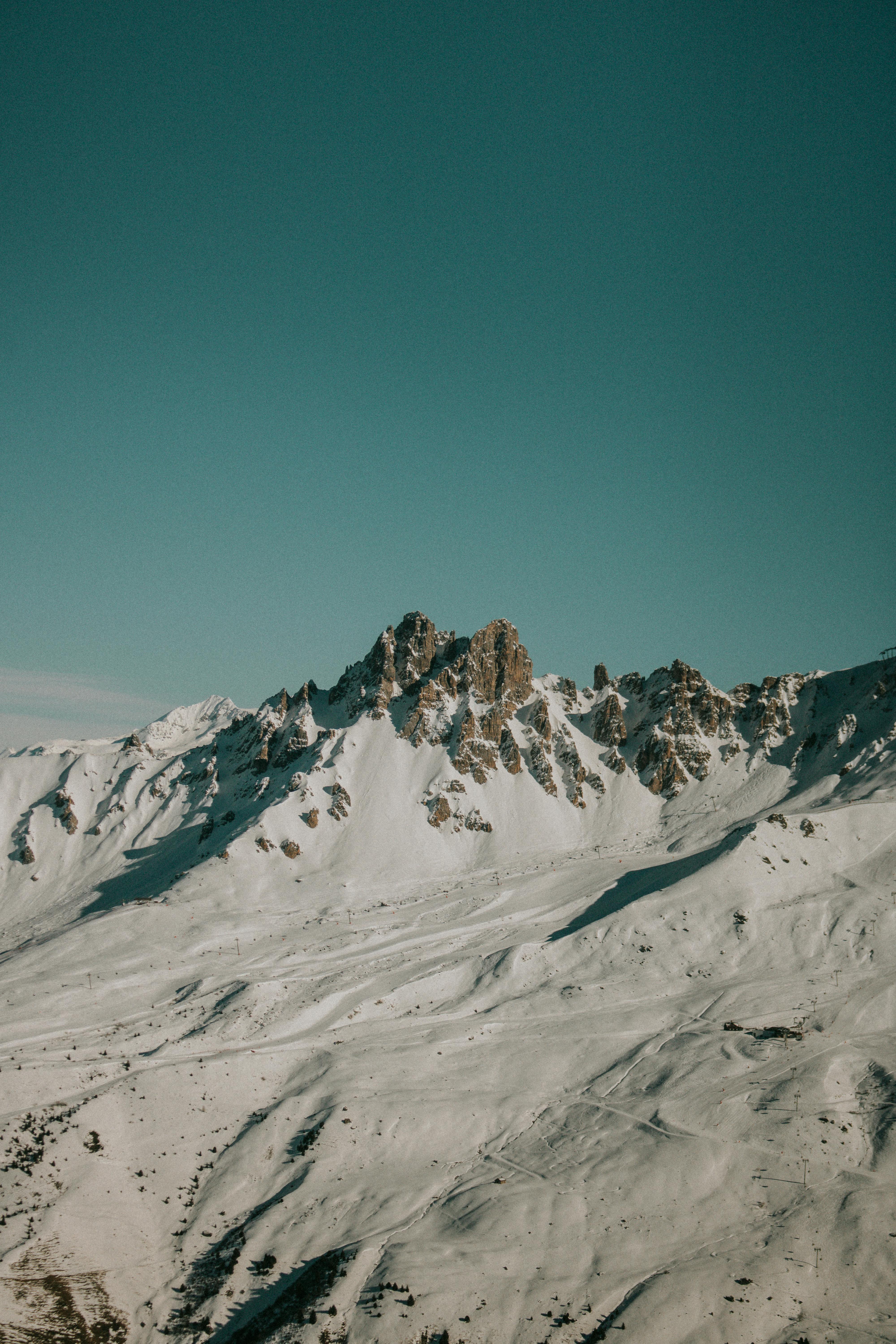 Beautiful snow-capped mountains under a clear sunny sky, perfect for winter landscapes.