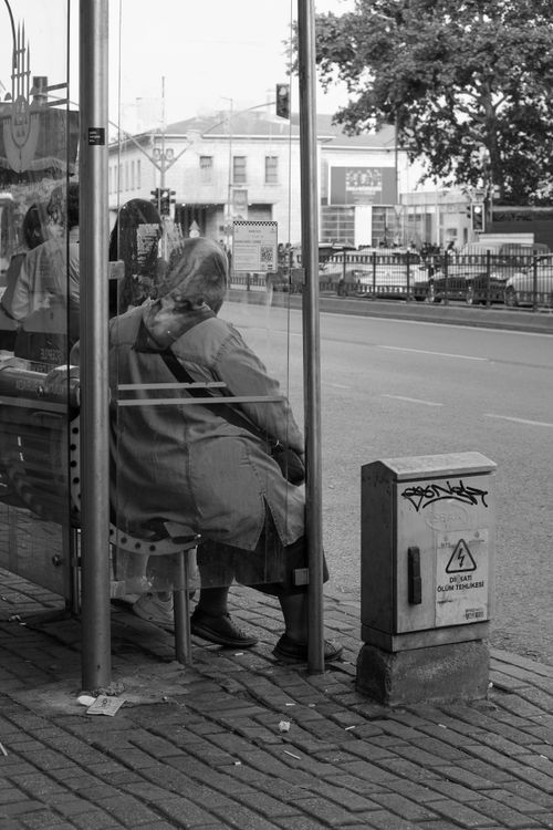 Free Monochrome image of people waiting at a city bus stop, capturing urban life. Stock Photo