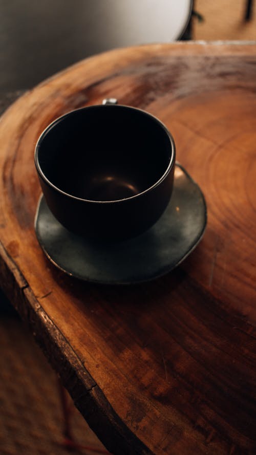 A black cup sitting on top of a wooden table