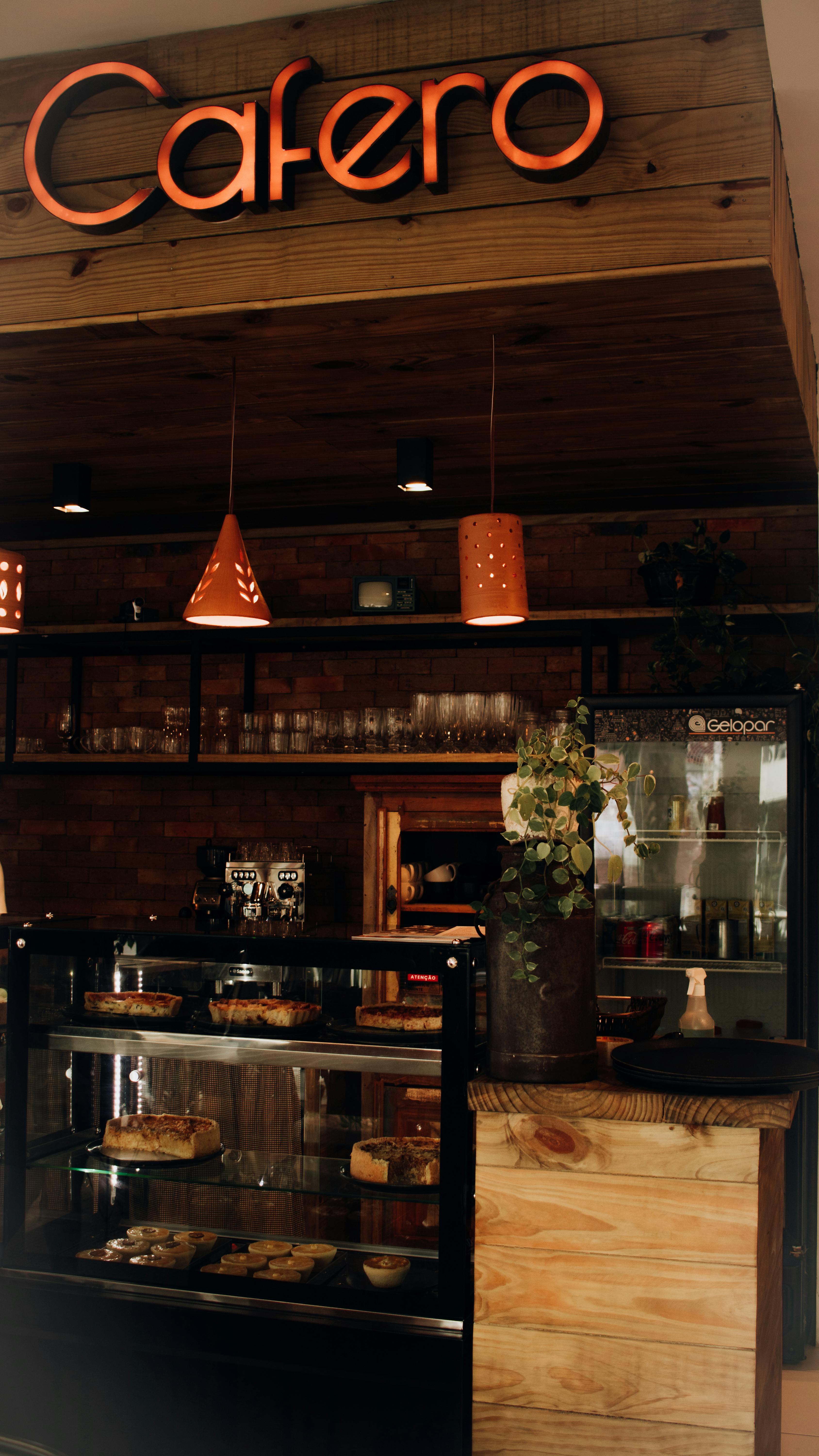 Warm bakery interior with dessert display case and wooden accents.