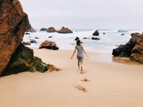 Free Photo of Woman Walking on Seashore Stock Photo