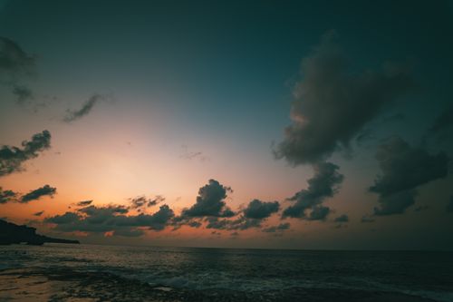Free Stunning sunset view over the ocean in Bali, Indonesia, with clouds enhancing the serene atmosphere. Stock Photo