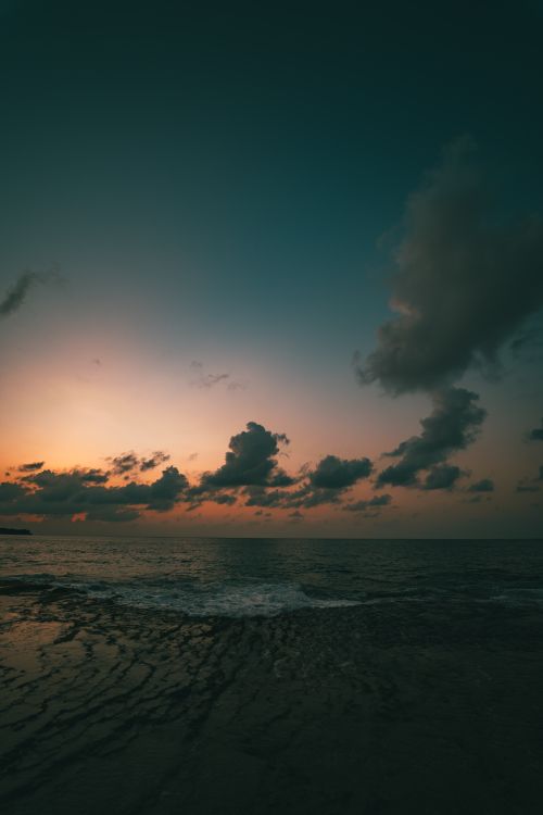Free Breathtaking sunset in Bali with dramatic clouds and serene ocean waves. Perfect for travel and nature lovers. Stock Photo