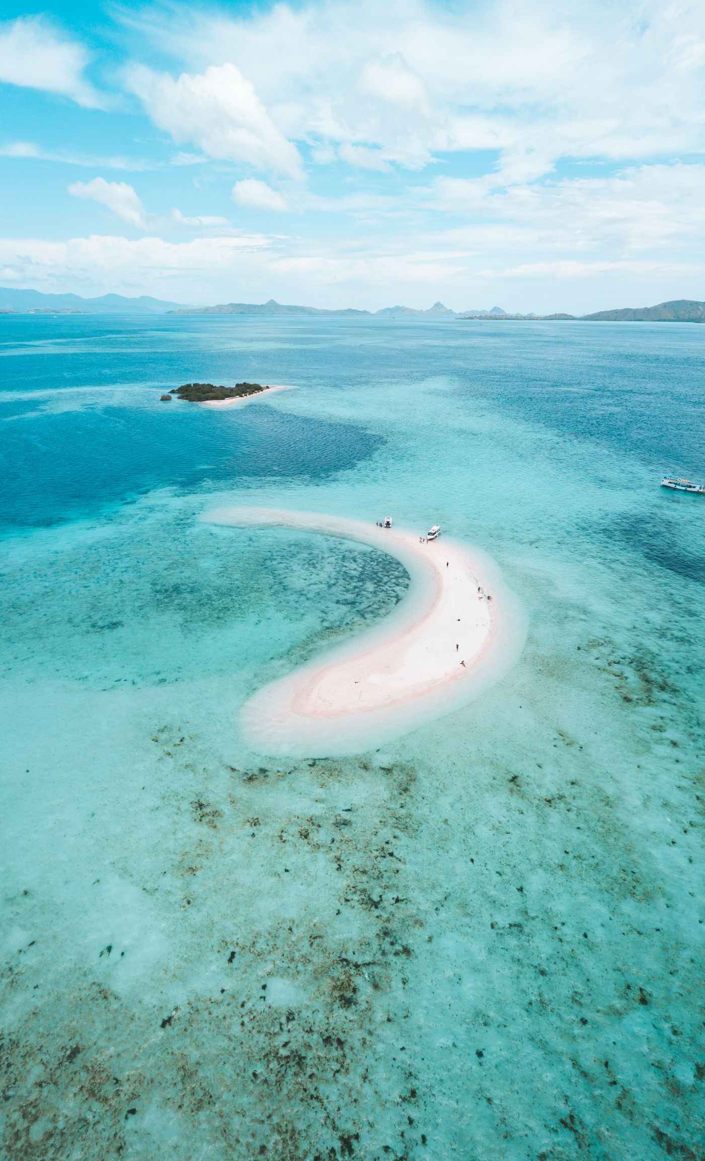 Aerial view of the pink-tinted sand and turquoise water of Pink Beach, Komodo Island, Indonesia