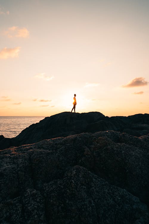 Person Standing on Rock Mountain Fronting the Sea