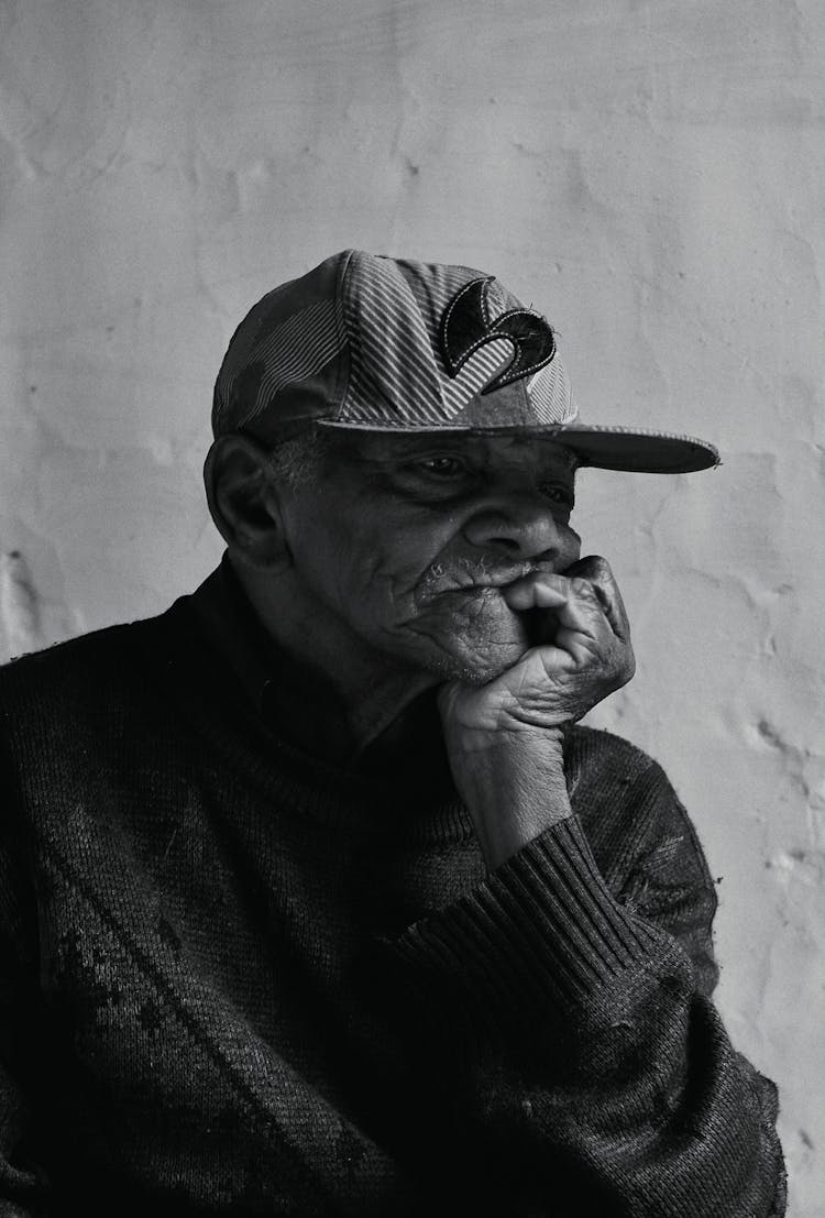 Portrait Photo Of Elderly Man Leaning Chin On His Hand Palm