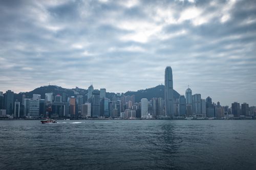 Free Explore the modern Hong Kong skyline with dramatic clouds and reflections on the sea. Stock Photo