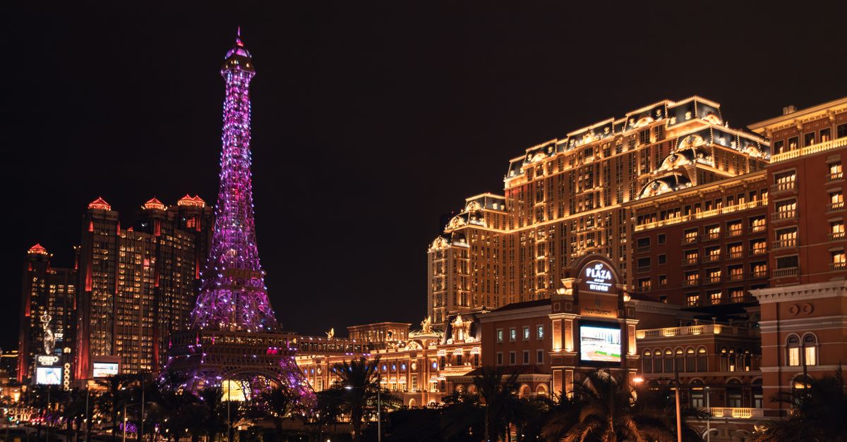 Viajero con el móvil y una eSIM para Macao ante los casinos iluminados de Cotai