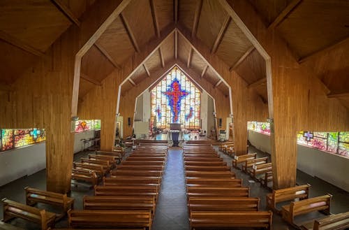 A church with wooden pews and stained glass windows