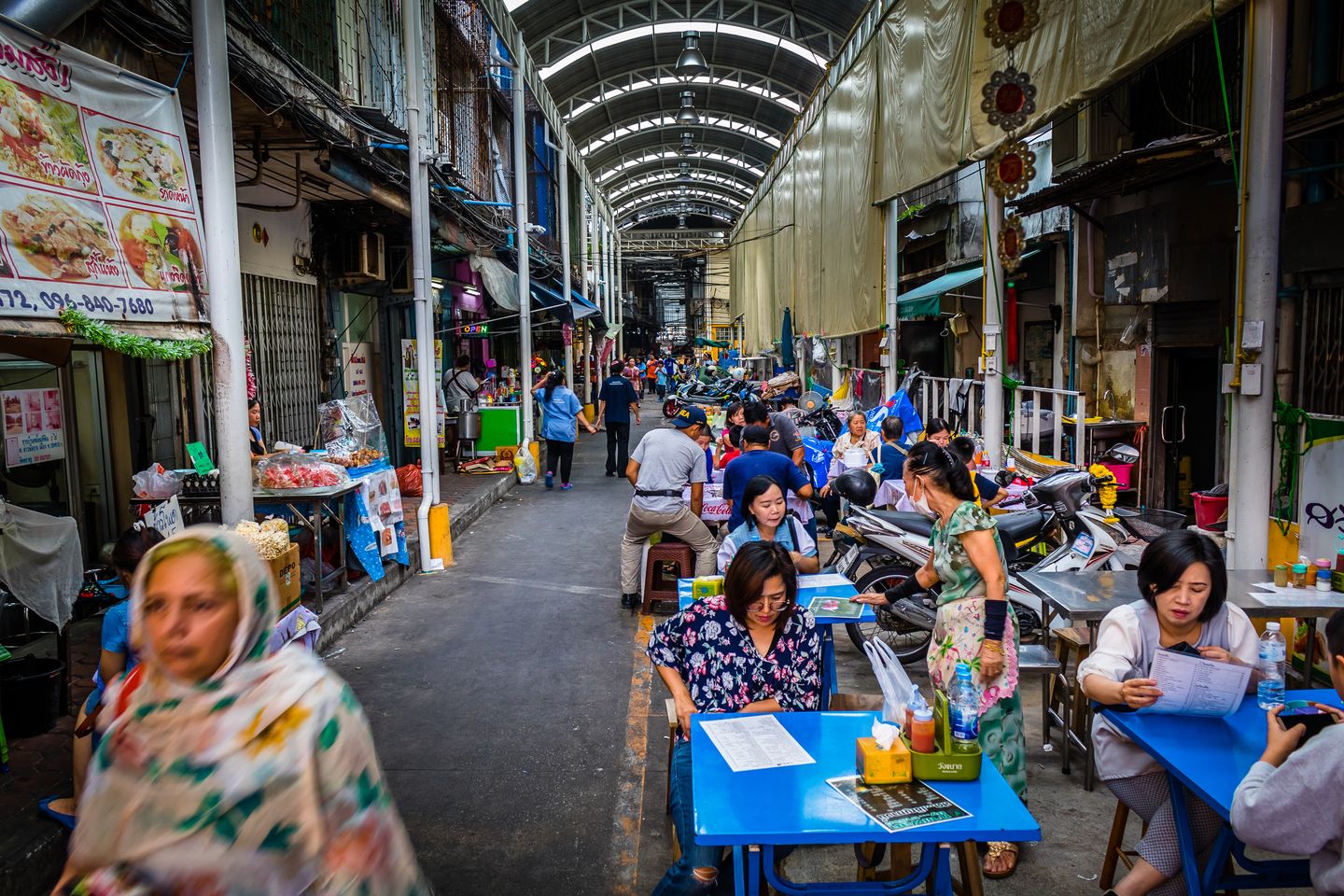 Explorez un marché de rue animé à Chiang Mai, Thaïlande, avec des étals vibrants et des foules diversifiées.