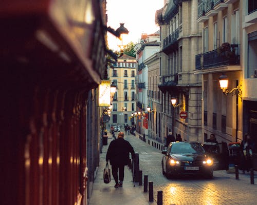A person walking down a narrow street in a city