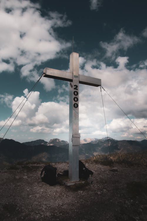 A cross on top of a mountain with a sign that says, the cross of the mountain