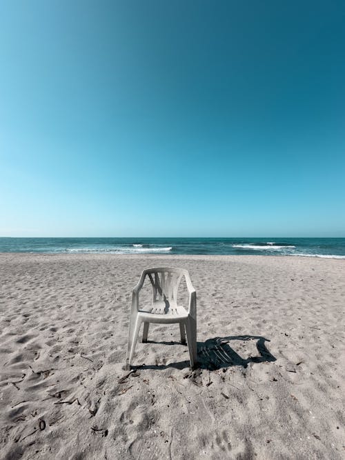 A chair on the beach with the ocean in the background