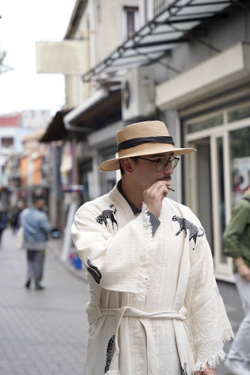 Man in Hat and White Robes Smoking Cigarette