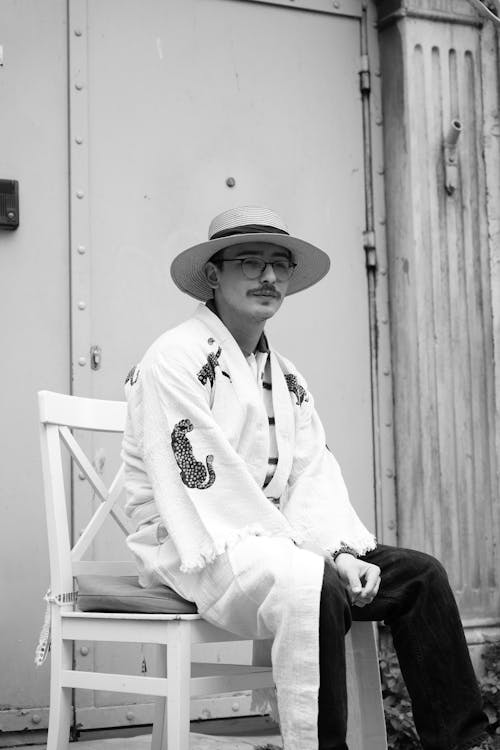 A man in a hat sitting on a chair