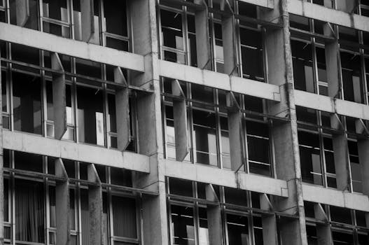 A striking black and white image showcasing the facade of a modern urban building with geometric patterns.