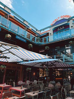 Colorful outdoor seating area at Kingly Court, London, under striped umbrellas.